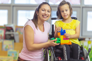 Photo of a mother with her daughter who has special needs and uses a wheelchair. This illustrates the need for Special Needs Trusts in North Carolina