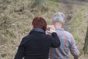 Two people walk, with one providing support to the other. This illustrates the special role of caregivers.