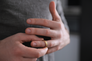 Photo of a man taking off his wedding ring. This symbolized Estate Planning After Divorce in North Carolina