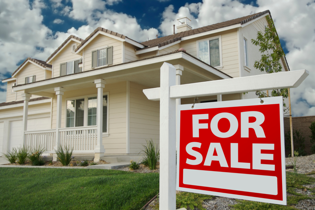 Photo of a house in the background with a for sale sign in the front yard. This illustrates the article's main topic of selling a family home after a death.