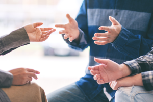 Photo of people's hands in motion as part of a conversation. This illustrates the topic "5 Important Questions to Ask Your Estate Planning Attorney"