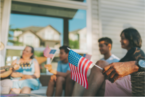 Patriotic image of a family sitting together. One is holding an American flag. This symbolizes the freedom felt from avoiding probate with a living trust. This ties in to the 4th of July holiday and theme when this post was published.