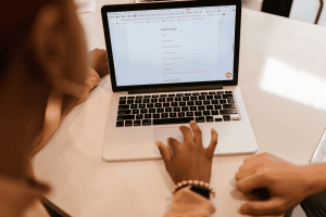 Image of people working on a laptop and filling out a form to illustrate the diy nature of the question Can you Set up a Trust without an Attorney
