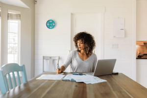 photo of a woman at a laptop working on finances to illustrate: the role of a Trustee and how you can determine the level of discretion they have